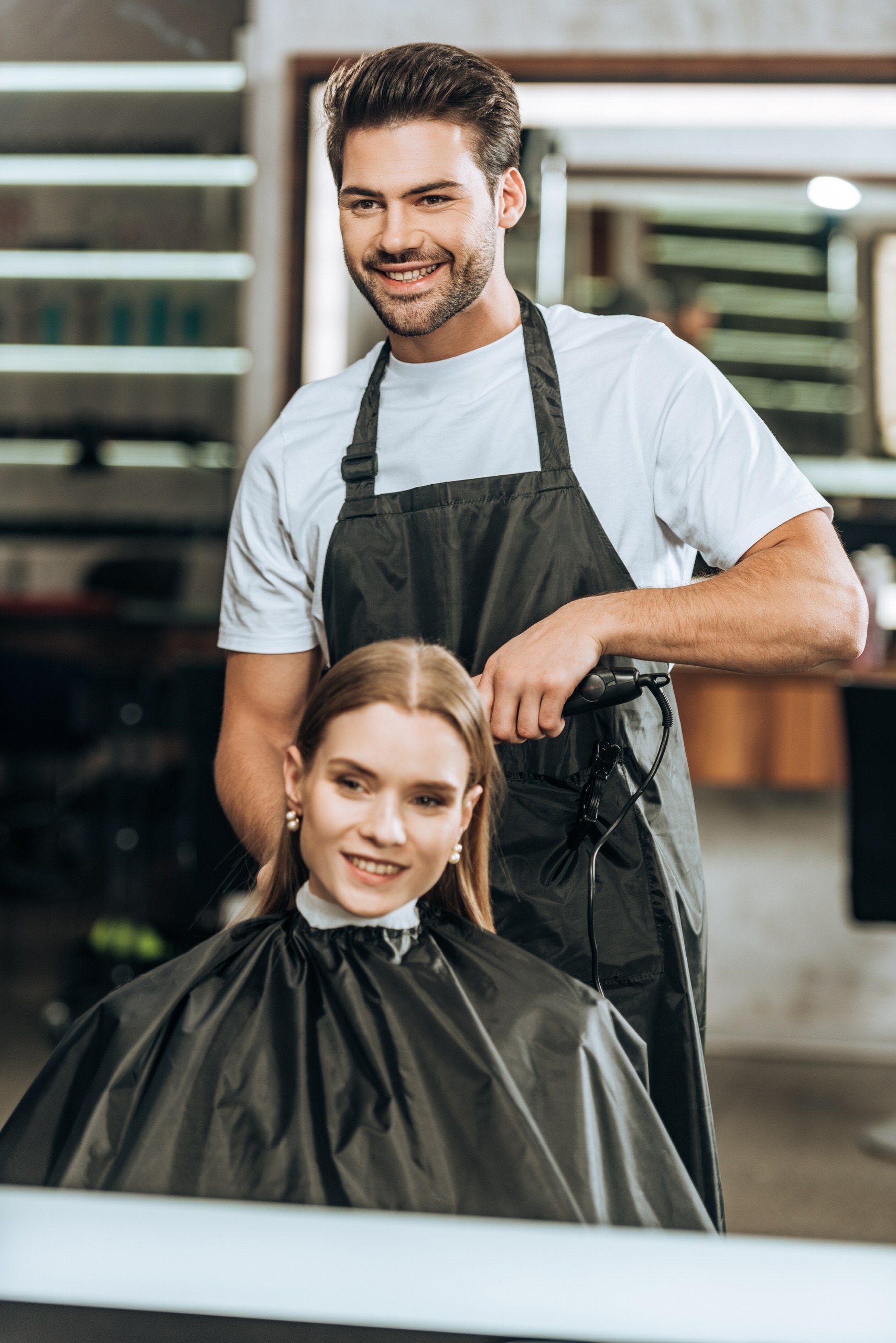 Se lancer dans le bien-être : coiffeur réalisant un brushing en salon, accompagné par Normizy pour constituer son dossier ERP